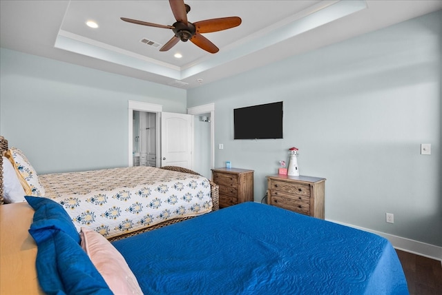 bedroom with a raised ceiling, ceiling fan, and dark hardwood / wood-style floors