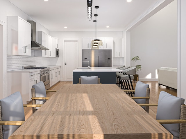 dining room featuring light hardwood / wood-style floors, crown molding, and sink