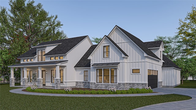 modern inspired farmhouse featuring a front lawn, a porch, and a garage