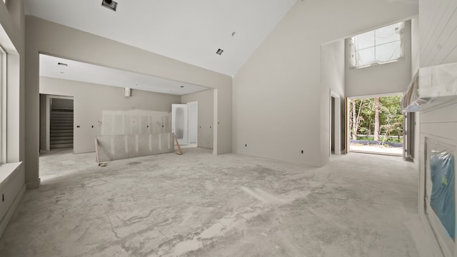 unfurnished living room with high vaulted ceiling