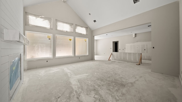 unfurnished living room featuring high vaulted ceiling