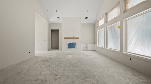 unfurnished living room with a fireplace and high vaulted ceiling