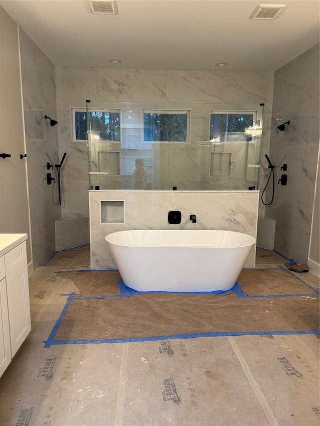 bathroom featuring vanity, tile walls, and plus walk in shower