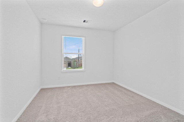 empty room featuring visible vents, baseboards, and carpet