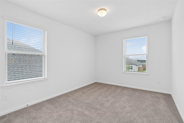 carpeted spare room featuring baseboards