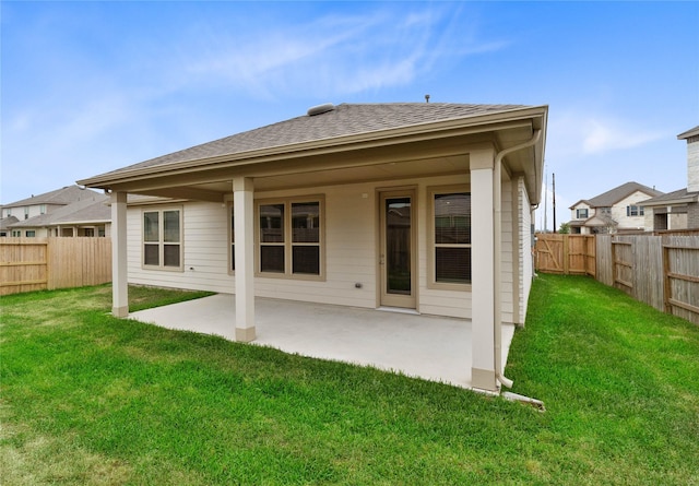 back of house with a lawn, a patio, and a fenced backyard