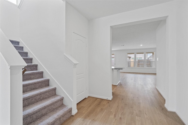 staircase with baseboards and wood-type flooring