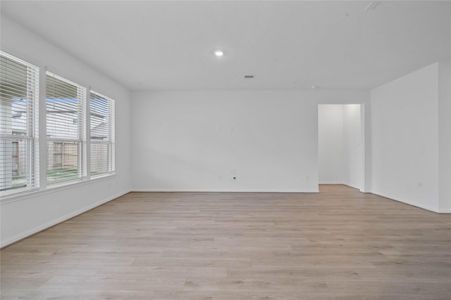 unfurnished room with recessed lighting, baseboards, and light wood-type flooring