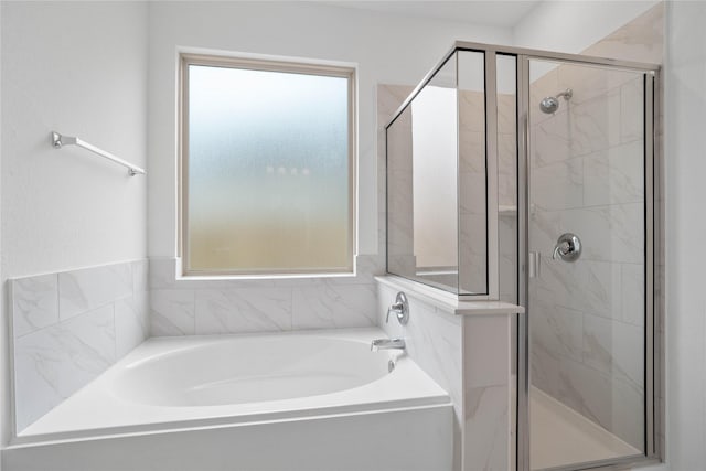 bathroom with a bath and a stall shower