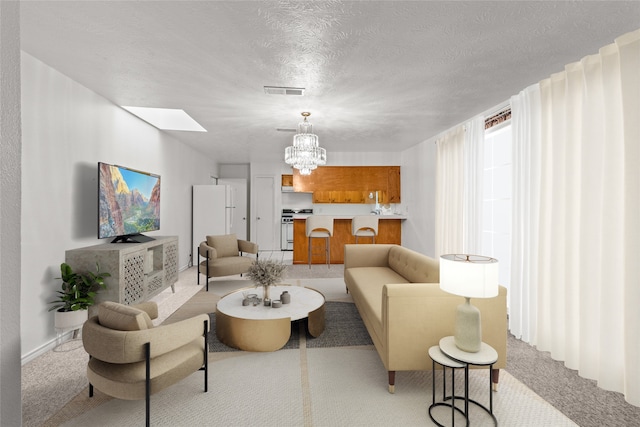 carpeted living room with a textured ceiling and an inviting chandelier