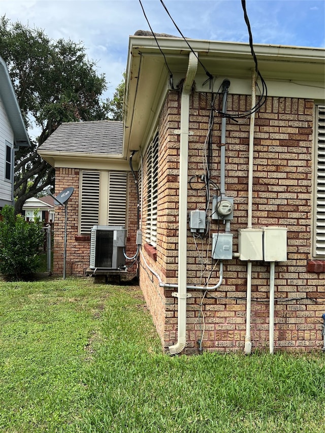 view of property exterior with a lawn and central air condition unit