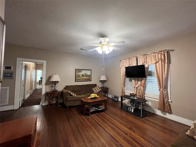 living room with dark hardwood / wood-style flooring, a healthy amount of sunlight, and ceiling fan