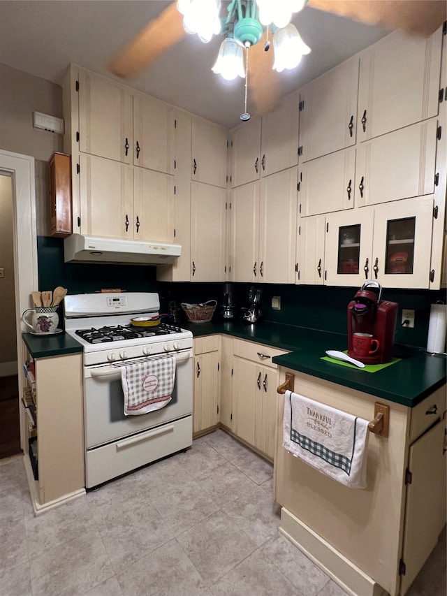 kitchen with white range with gas stovetop, light tile patterned floors, and ceiling fan