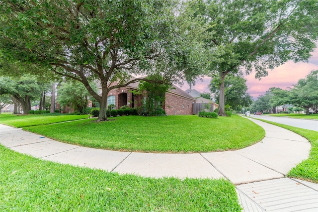 obstructed view of property featuring a front lawn and brick siding