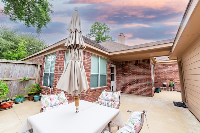 patio terrace at dusk with fence and outdoor dining space