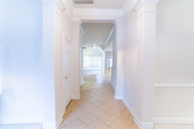 corridor with crown molding, light tile patterned flooring, visible vents, and ornate columns