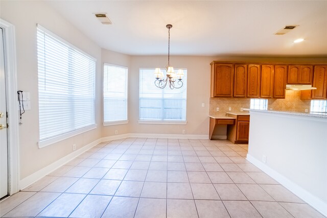 kitchen featuring brown cabinets, visible vents, light countertops, and decorative backsplash