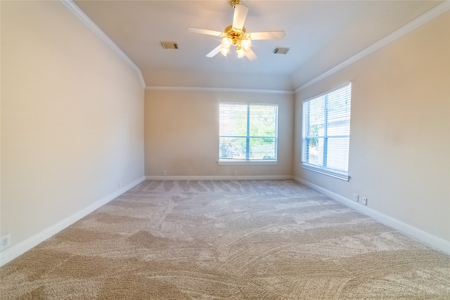 empty room with baseboards, carpet, visible vents, and crown molding