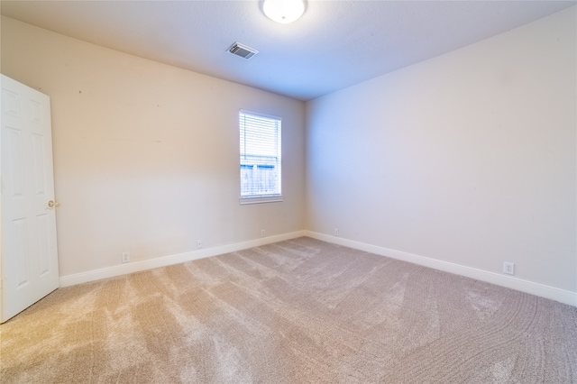 carpeted empty room with visible vents and baseboards