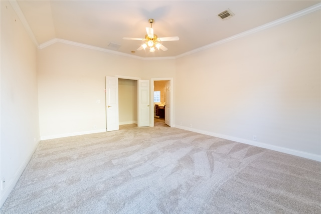 spare room with visible vents, ornamental molding, light carpet, ceiling fan, and baseboards