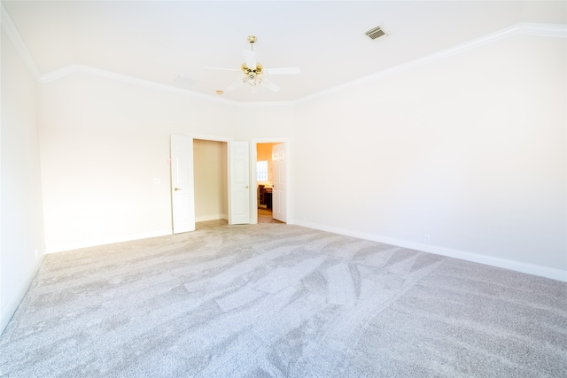 empty room featuring light carpet, baseboards, visible vents, and crown molding