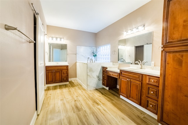 full bathroom with two vanities, a sink, a bath, and wood finished floors