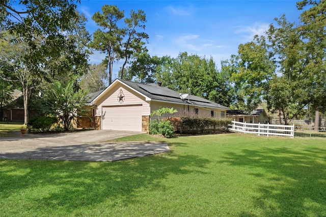 exterior space with a yard, a garage, and solar panels