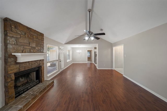 unfurnished living room featuring a stone fireplace, lofted ceiling, dark wood-type flooring, and ceiling fan with notable chandelier