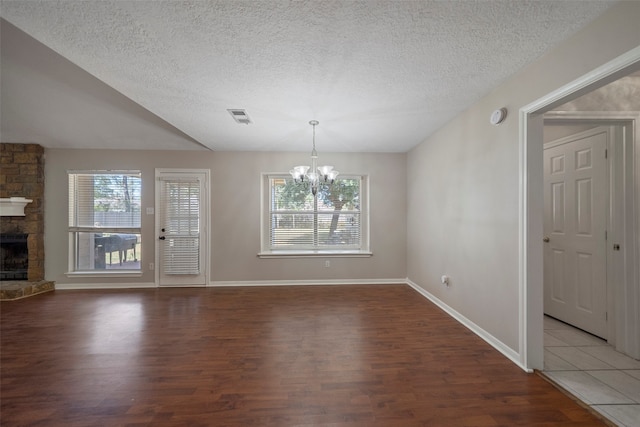 unfurnished dining area featuring dark wood-type flooring, a textured ceiling, and a wealth of natural light