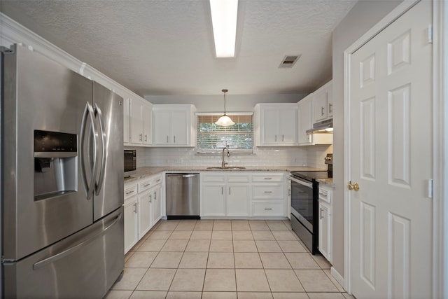 kitchen with sink, pendant lighting, white cabinetry, light tile patterned floors, and appliances with stainless steel finishes