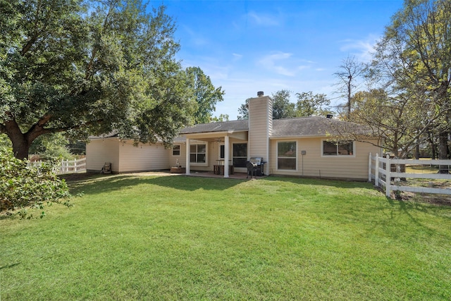 rear view of property featuring a patio area and a yard