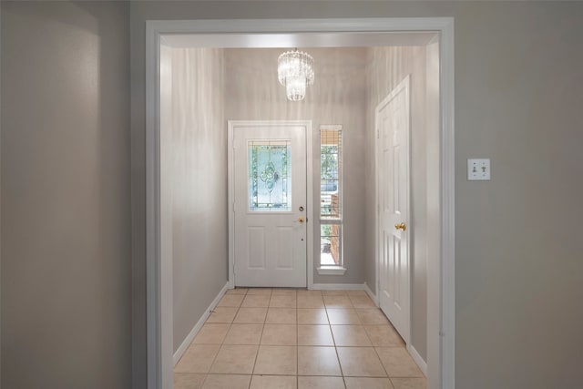 foyer entrance with light tile patterned flooring and an inviting chandelier