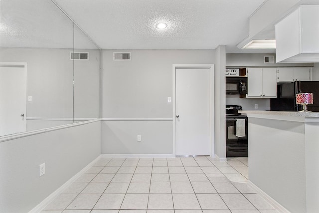 kitchen featuring light tile patterned floors, a textured ceiling, white cabinetry, and black appliances