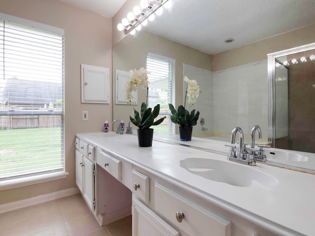 bathroom with vanity, a shower with shower door, plenty of natural light, and tile patterned flooring