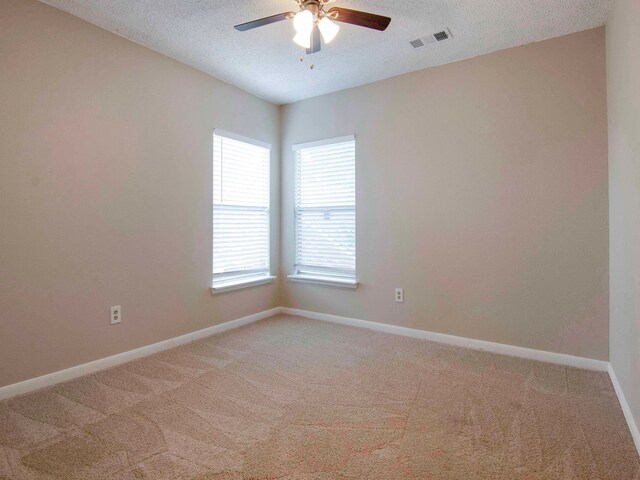 empty room featuring ceiling fan, a textured ceiling, and carpet floors