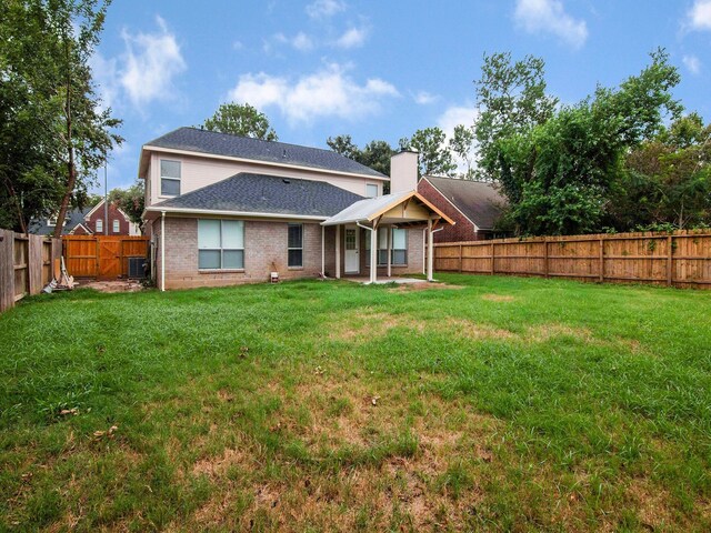 rear view of property featuring a yard