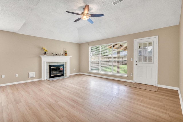 5635 Sage Manor Dr, Houston, TX 77084 - unfurnished living room featuring a textured ceiling, ceiling fan, visible vents, light wood-type flooring, and a tiled fireplace
