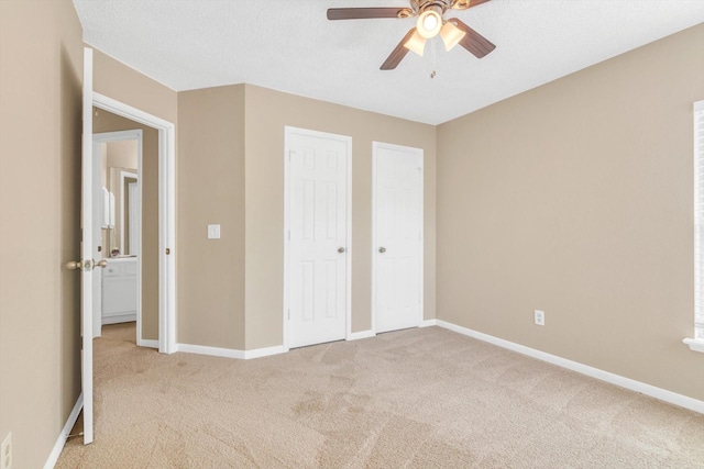 5635 Sage Manor Dr, Houston, TX 77084 - unfurnished bedroom featuring multiple closets, baseboards, a ceiling fan, and light carpet