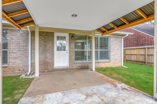 5635 Sage Manor Dr, Houston, TX 77084 - property entrance with fence, a yard, a patio, and brick siding