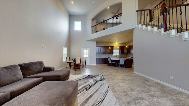 living room featuring a towering ceiling and light tile patterned floors