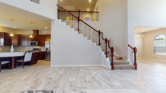 stairs featuring an inviting chandelier and a high ceiling