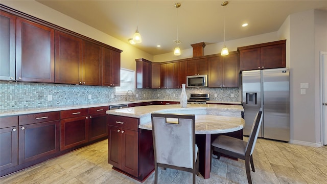 kitchen with appliances with stainless steel finishes, a kitchen island, light stone countertops, and decorative backsplash