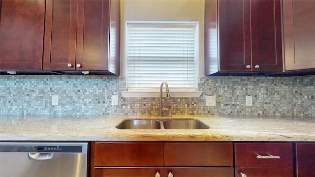 kitchen featuring light stone countertops, dishwasher, tasteful backsplash, and sink