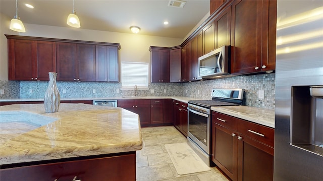 kitchen featuring light stone counters, appliances with stainless steel finishes, light tile patterned floors, and backsplash