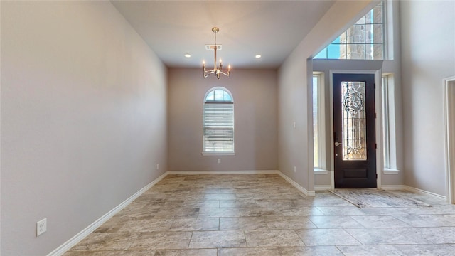 tiled entryway featuring a chandelier