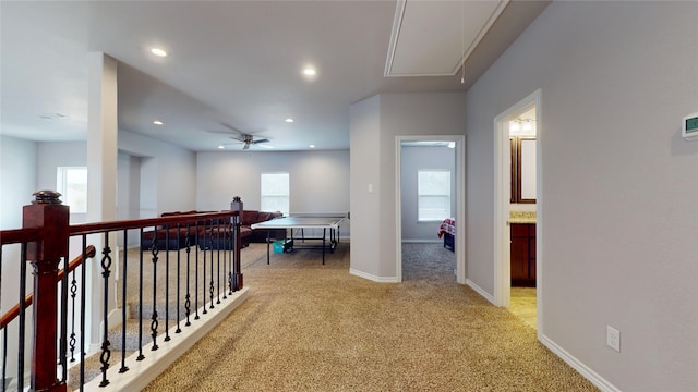 hallway featuring light colored carpet and a healthy amount of sunlight