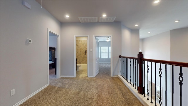 hall featuring light colored carpet