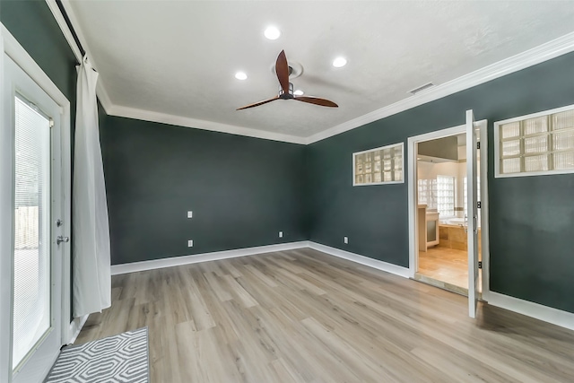 empty room with crown molding, ceiling fan, hardwood / wood-style floors, and a healthy amount of sunlight