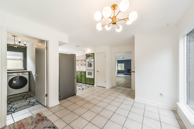 interior space featuring washer / clothes dryer, an inviting chandelier, and light tile patterned flooring