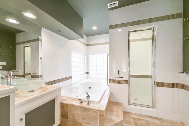 bathroom with vanity, tile walls, plus walk in shower, and tile patterned floors